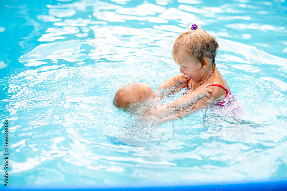 Joyful little girl embracing a baby boy in the pool, smiling with eyes closed on a sunny day Joyful little girl embracing a baby boy in the pool, smiling with eyes closed on a sunny day