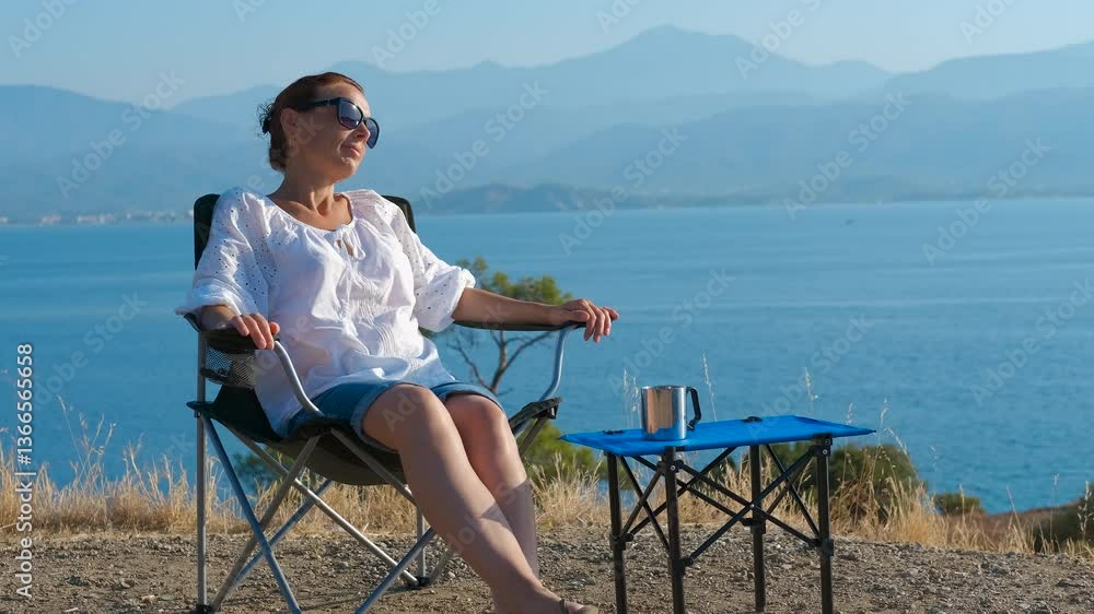 custom made wallpaper toronto digitalRelaxing in a camp chair by the sea. Woman sits comfortably in a camping chair, soaking in the stunning sea view. Wearing sunglasses and a white shirt, she enjoys a moment of peace and tranquility
