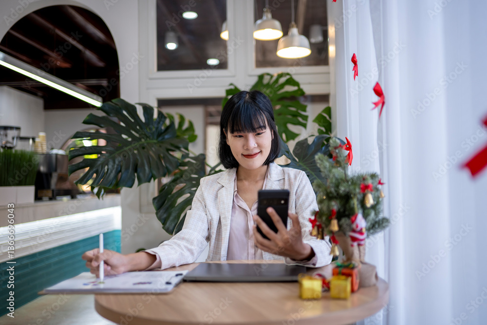 A woman is sitting at a table with a laptop and a cell phone A woman is sitting at a table with a laptop and a cell phone