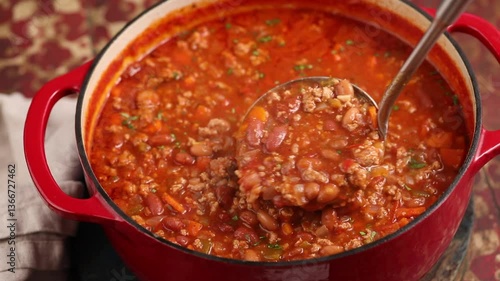 Beef chili in a pot close up, scooping some up with a ladle