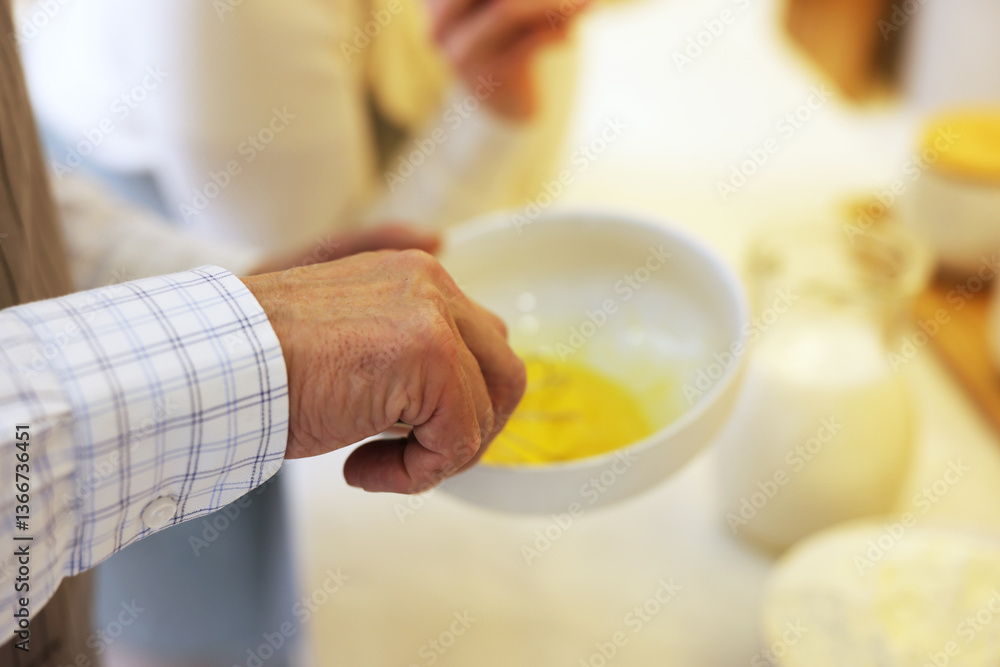 Senior man whisking eggs in kitchen, closeup Senior man whisking eggs in kitchen, closeup