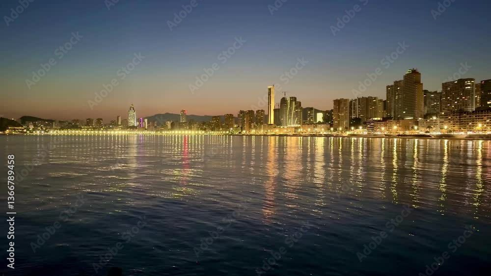 A captivating sunset view of a modern city skyline along the water's edge, reflecting lights across the surface. A captivating sunset view of a modern city skyline along the water's edge, reflecting lights across the surface.