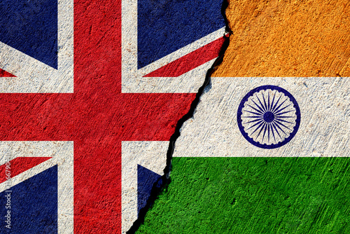 cracked concrete wall with painted united kingdom and india national flags, economical or political relations concept