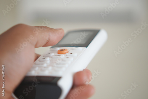 Wallpaper Mural Remote control in hand adjusting air conditioning settings indoors Torontodigital.ca