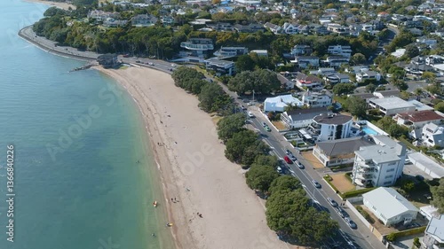 Wallpaper Mural Aerial view of Kohi beach in Auckland, New Zealand. People are swimming, sunbathing, and walking along the beach. Cars drive along the road next to the beach. KOHIMARAMA, AUCKLAND, NZ Torontodigital.ca