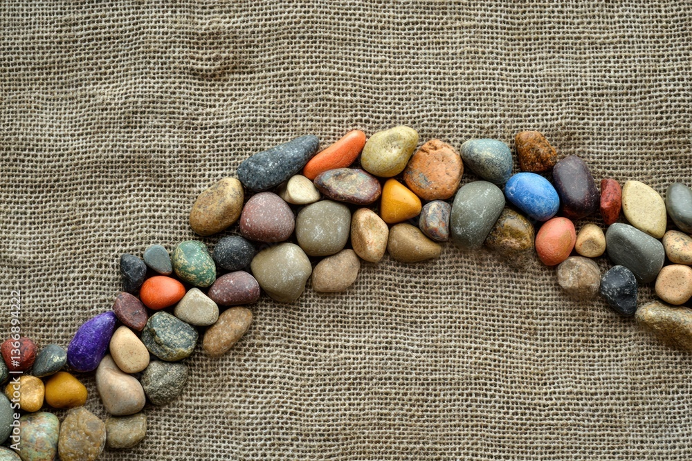 Colorful River Stones Arranged on Natural Fabric Background for Texture