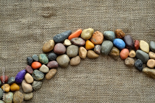 Colorful River Stones Arranged on Natural Fabric Background for Texture