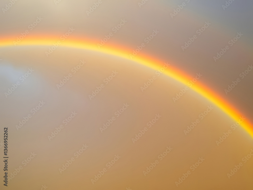 Obraz premium Vibrant Rainbow Arching Across Cloudy Sky Nature's Colorful Phenomenon.