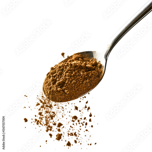 Brown powder on a spoon spilling onto black background,