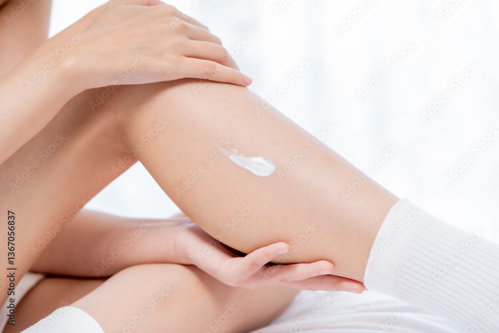 Fototapeta premium Nourishing skin care is essential for maintaining healthy and radiant skin. This showcases person applying moisturizing cream to their leg, highlighting importance of skin care in daily routines