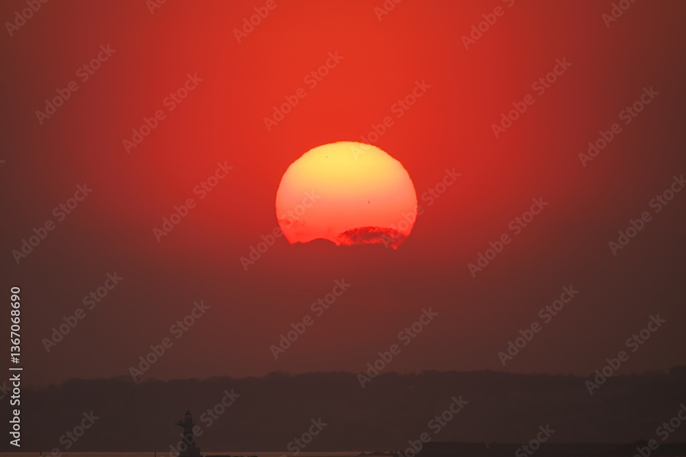 Obraz premium スギ花粉の飛散が始まっていて、太陽の周りに花粉光環が現れている。 ちなみに八丈島は亜熱帯のため杉が自生しておらず、かつ本土から300kmほど離れているので、花粉が飛ぶことはない。 東京湾から眺める美しい夕陽。 東海汽船東京湾～伊豆諸島八丈島、太平洋航路の橘丸船上-2025 