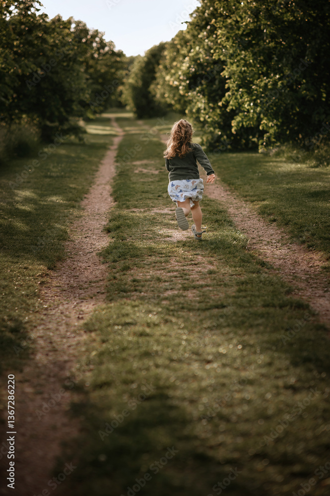 Girl runs on the road in the park along the trees. Girl runs on the road in the park along the trees.