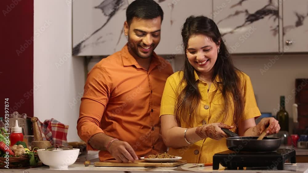Husband and wife are both cooking together in the kitchen Husband and wife are both cooking together in the kitchen