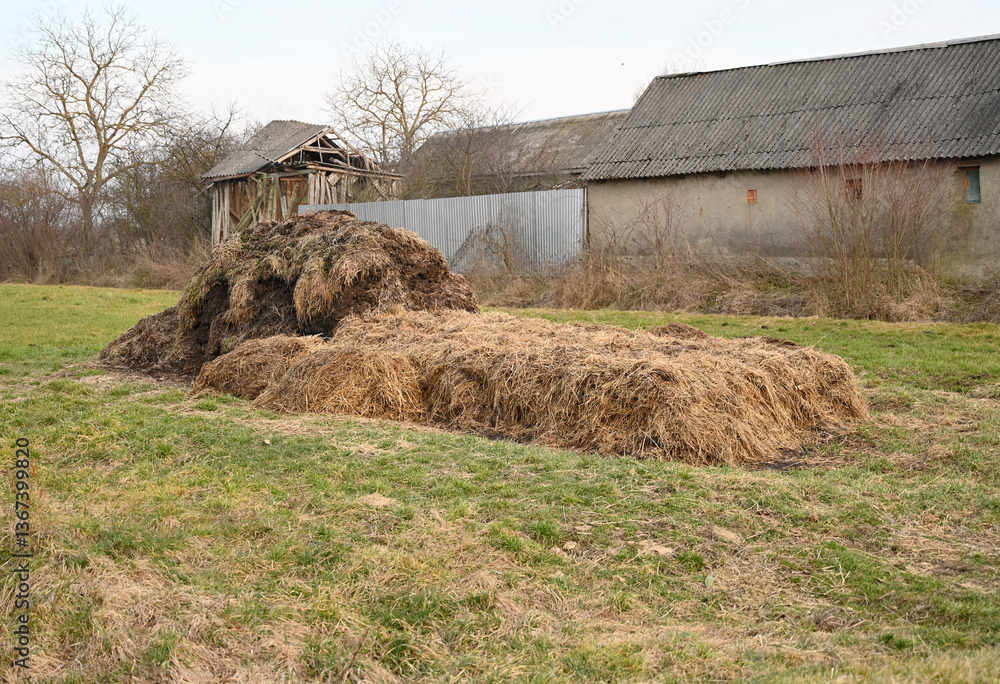Haystack positioned in a rural landscape near an old barn