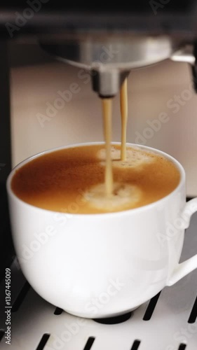 Vertical Video of Process of making coffee by coffee machine into cup, espresso coffee coming out from an automated coffemaker machine. Beverage drink for breakfast