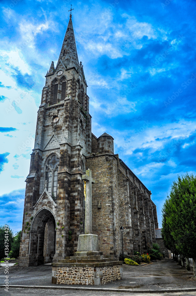 Fototapeta premium The beautiful Catholic Church of Sains amidst rural elegance, traveling towards Le Mont Saint Michel, France