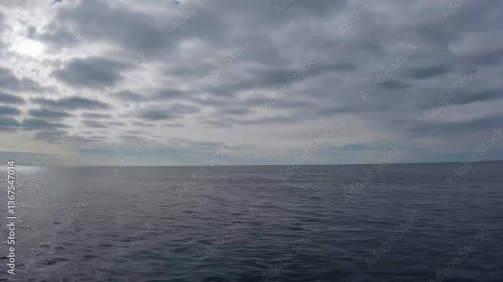 Dramatic overcast sky unfolds above serene ocean horizon at dawn Dramatic overcast sky unfolds above serene ocean horizon at dawn