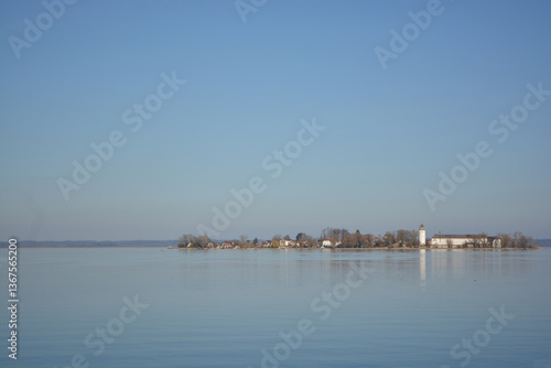 Fraueninsel, Frauenchiemsee on lake Chiemsee in the morning sunrise with boat, Sailboat, church, monastery. Bavaria, Bayern, Germany