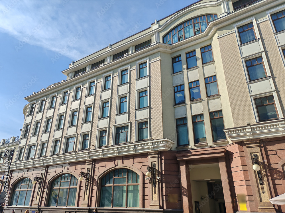 Fototapeta premium historical pink building with multiple floors, adorned with decorative features and air conditioning units on its windows. The combination of classic design and modern amenities highlights urban