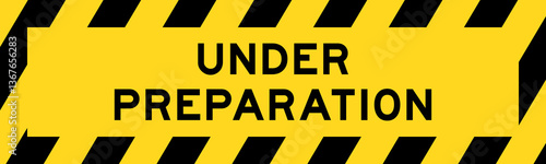 Yellow and black color with line striped label banner with word under preparation