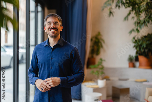 Canvas-taulu Startup founder smiling in modern office with plants, embracing green workspace