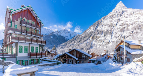View of chalets and snow covered mountains in Courmayeur at sunrise in winter, Courmayeur, Aosta Valley, Italian Alps