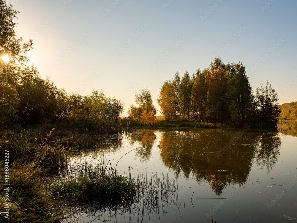 Fototapeta premium River landscape on a sunny autumn morning. The serenity and tranquility of an autumn morning on the banks of a narrow rural river.