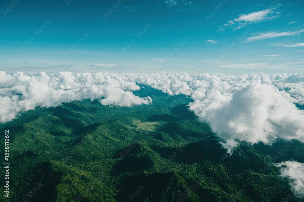 Obraz premium Lush green mountains under a vast blue sky, partially covered by fluffy white clouds