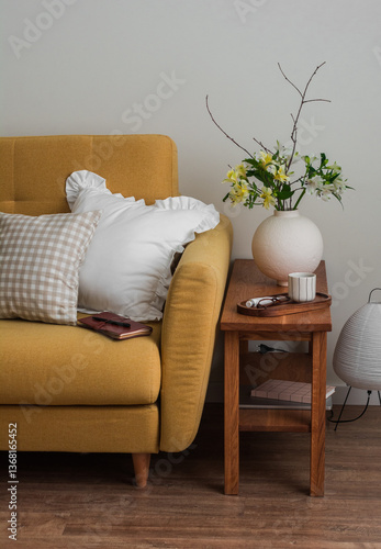 Cozy home - yellow sofa, wooden bench with a vase of fresh flowers, paper lamp in the living room interior