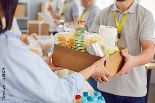 Food box giving to help, caring volunteer group working in charitable food foundation, make donation to needy, charity, separating donations stuff, food bank stocks, basic need provisions, free meal