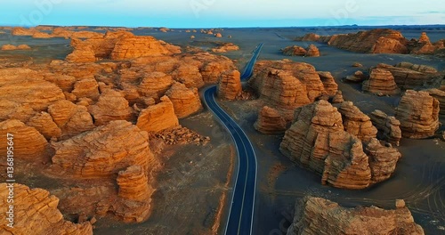 Aerial view of winding road through spectacular yardang landform in Xinjiang at sunset