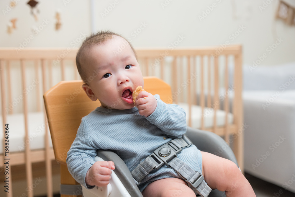 Baby eating snack sitting in high chair