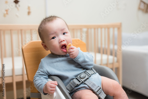 Obraz na płótnie Baby eating snack sitting in high chair w salonie