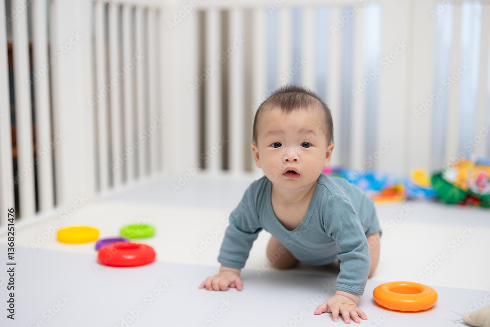 Baby crawling inside crib with colorful toys
