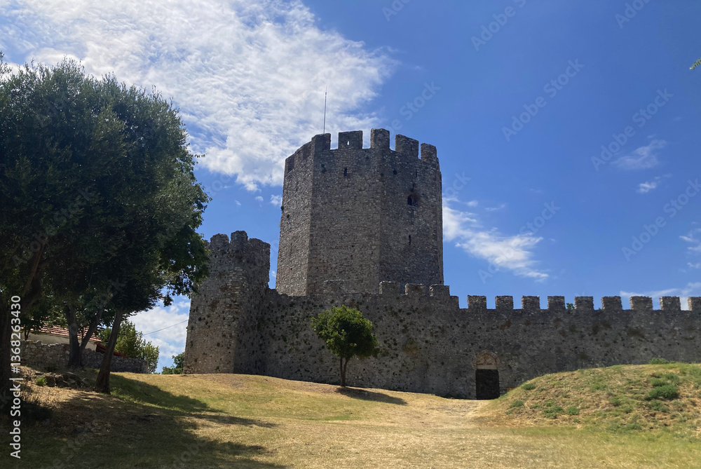 Medieval Greek Platamon castle tower and wall, part of an ancient fortress with historic architecture.Mountain view, sea view, and the Aegean Sea. Nature and history, blue sky, ocean view. Medieval Greek Platamon castle tower and wall, part of an ancient fortress with historic architecture.Mountain view, sea view, and the Aegean Sea. Nature and history, blue sky, ocean view.
