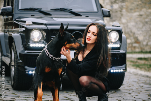 Stylish woman with doberman and luxury suv