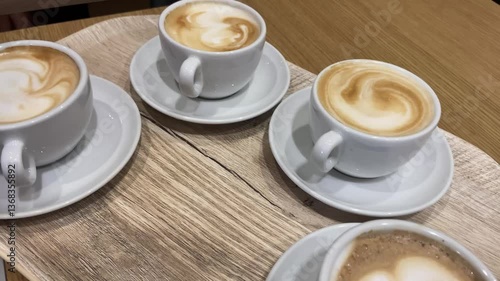 Top-Down View of a Tray with Four Cappuccinos on a Table