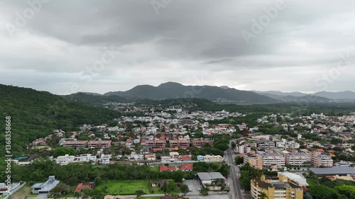 Scenic view of mountains and city under cloudy sky in late afternoon