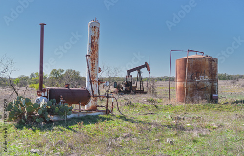 Idle, rusty oil well pumping equipment abandoned in field in West Texas.