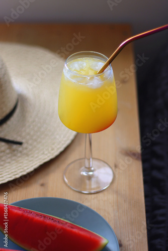 Obraz na płótnie Plate with watermelon slices, glass of orange juice or cocktail, straw hat, colorful beaded necklace and sunglasses on the wooden table. Summer essentials concept. Selective focus. w salonie