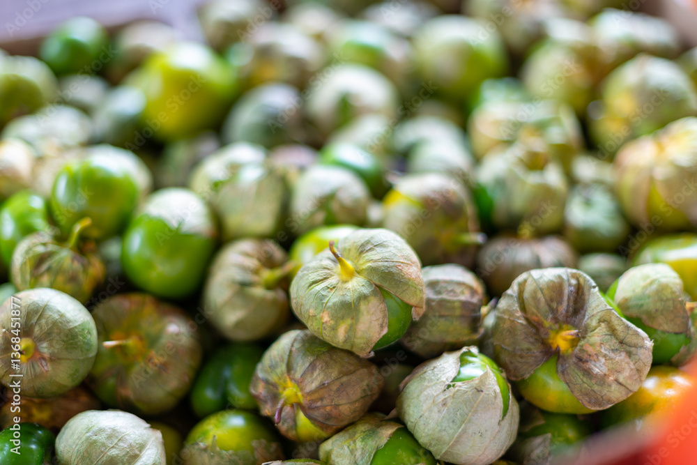 A bulk bin of fresh-pied cape gooseberries or husk cherries for sale at a farmers' market. The small, round, yellow, edible Peruvian fruit, ground cherries, have a dried papery husk on the outside. A bulk bin of fresh-pied cape gooseberries or husk cherries for sale at a farmers' market. The small, round, yellow, edible Peruvian fruit, ground cherries, have a dried papery husk on the outside.