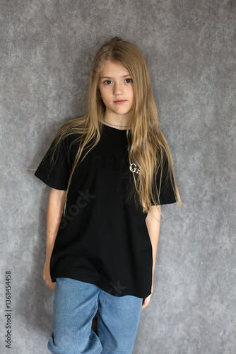 Young girl in a black shirt and jeans, posing for a portrait
