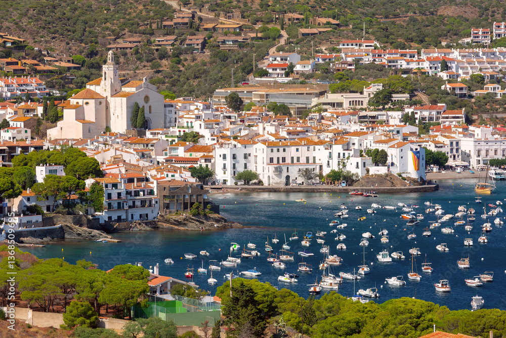 View over white houses and harbor with boats in Cadaques, Spain