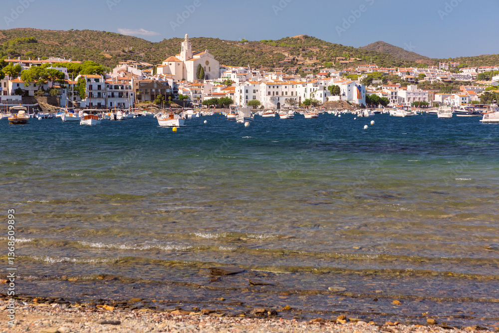 Shallow coastal water and boats facing Cadaques village in Spain