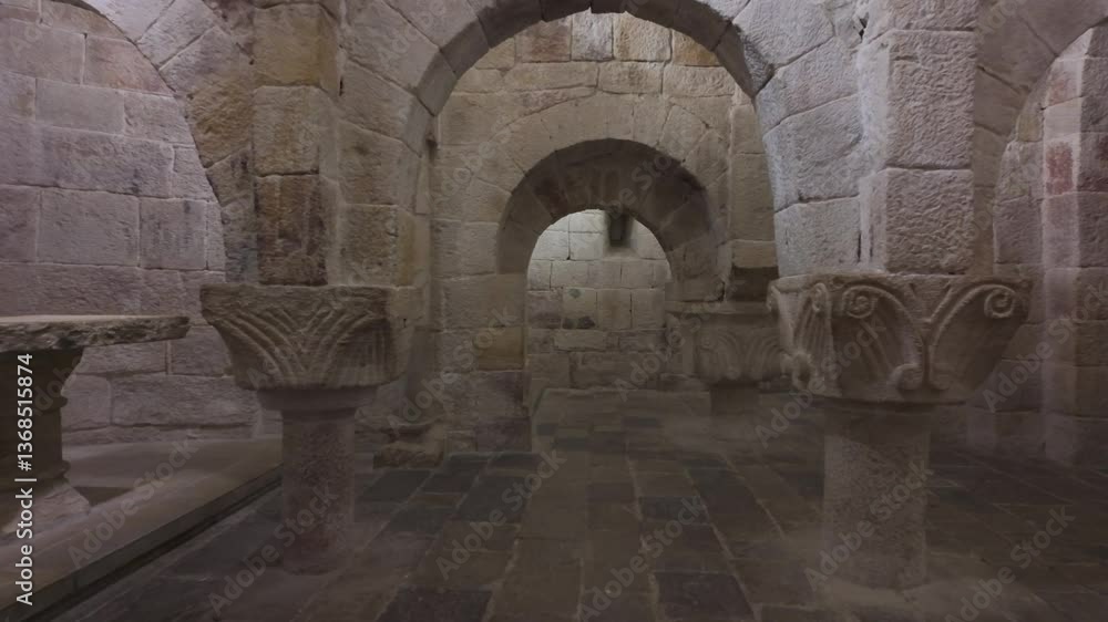 Horizontal video moving forward through the central nave of the crypt in Leyre Monastery, Spain. The footage reveals a sequence of Romanesque stone arches and columns Horizontal video moving forward through the central nave of the crypt in Leyre Monastery, Spain. The footage reveals a sequence of Romanesque stone arches and columns