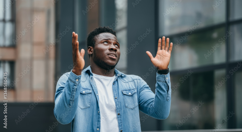 Obraz premium Young african male expressing joy in denim jacket outdoors