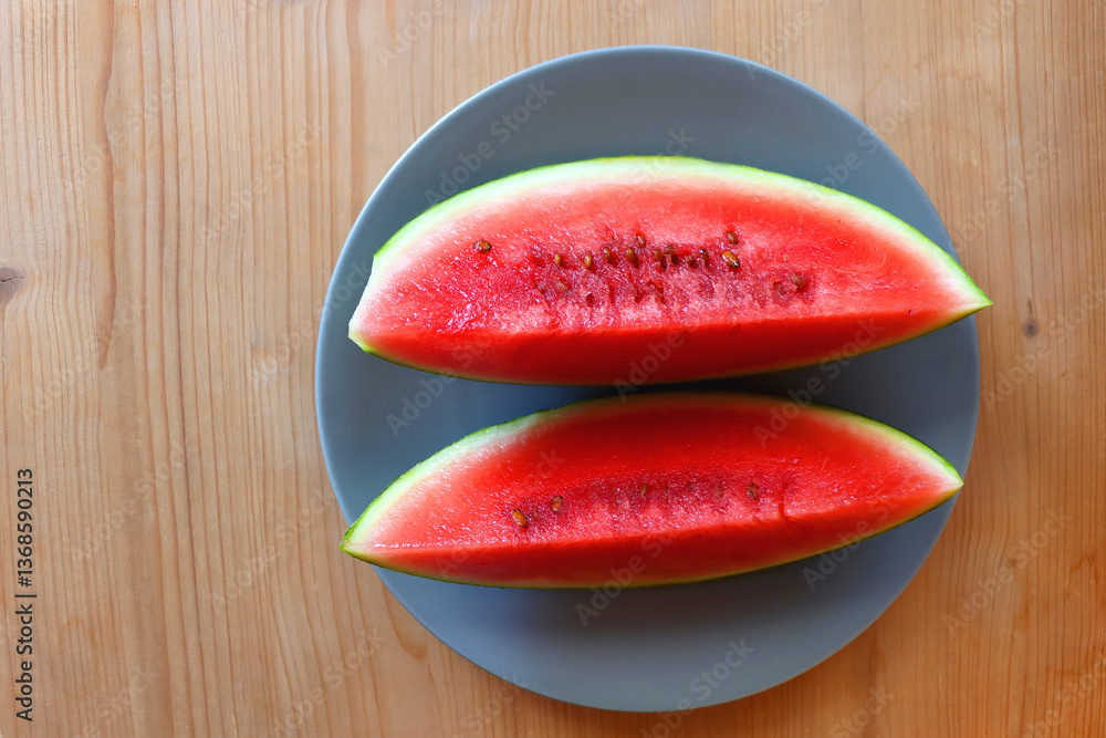 Plate with two watermelon slices on the table. Top view.