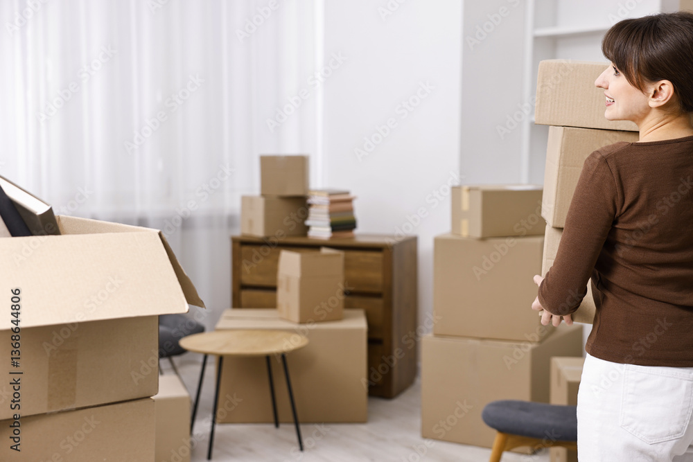 Moving day. Happy woman with cardboard boxes in her new home Moving day. Happy woman with cardboard boxes in her new home