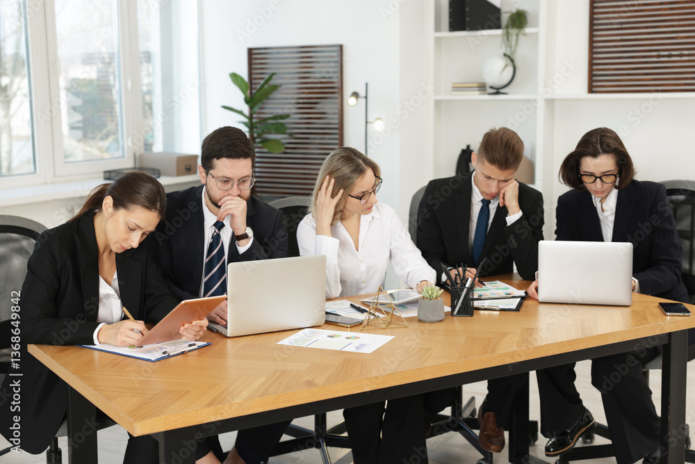 Obraz premium Coworkers with different devices working together at wooden table in office