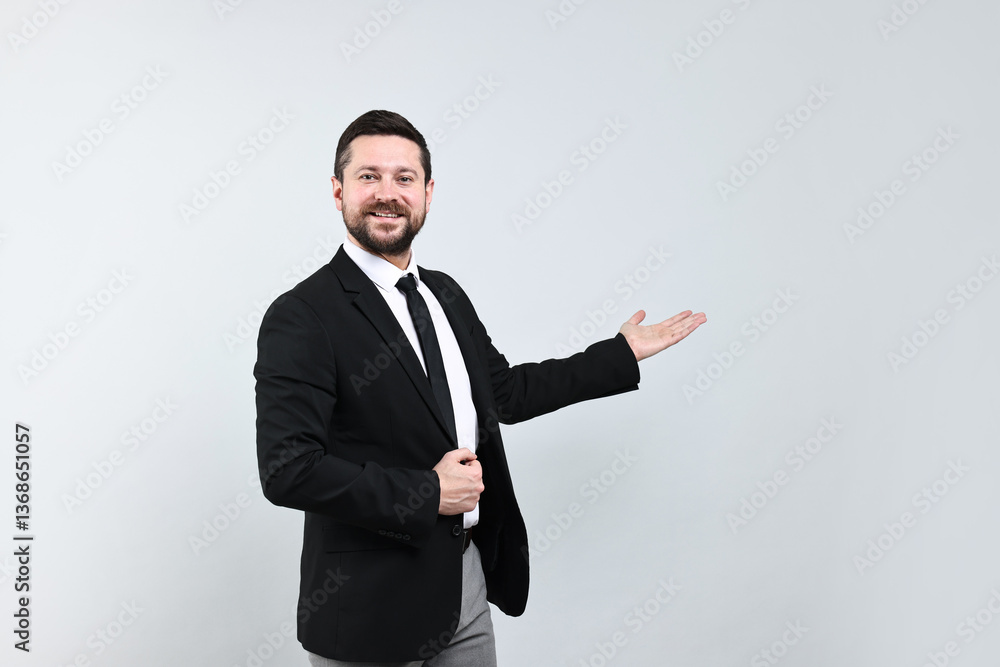 Happy businessman welcoming clients or partners on grey background Happy businessman welcoming clients or partners on grey background